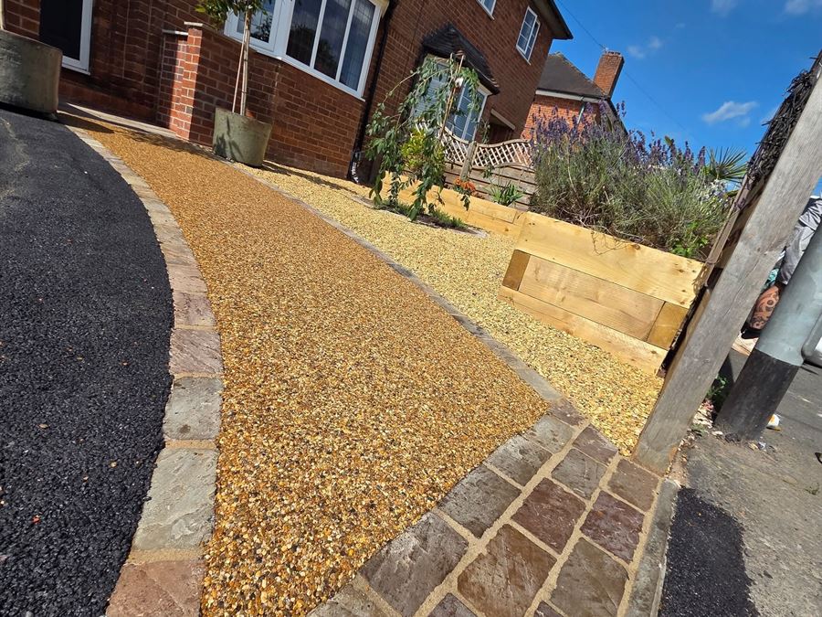 A gold resin bound path with sandstone borders leading to a front door